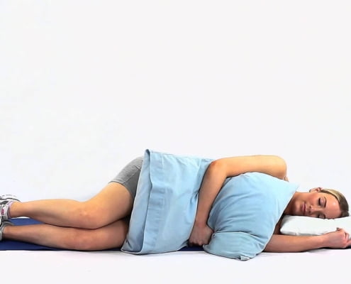 Beste slaaphouding bij frozen shoulder: op de gezonde zij met kussen als armsteun